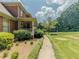 Landscaped side yard of a brick home with a walkway leading to the front porch at 3290 Spain Rd, Snellville, GA 30039