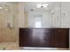 Bathroom with dual sink vanity, dark cabinetry, and a glass-enclosed shower with beige tile at 3325 Piedmont Ne Rd # 2104, Atlanta, GA 30305
