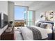 Bright bedroom features large windows with a beautiful view and comfortable modern decor at 3325 Piedmont Ne Rd # 2104, Atlanta, GA 30305