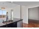 Kitchen sink area with dark cabinetry, granite countertop, stainless steel dishwasher, and hardwood floors at 3325 Piedmont Ne Rd # 2104, Atlanta, GA 30305