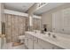 Well-lit bathroom with double sinks, white cabinets, large mirror, and tub-shower combination at 6302 Manassas Nw Pass, Acworth, GA 30101