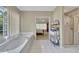 Relaxing bathroom featuring a soaking tub, a glass-enclosed shower, and a glimpse into a bedroom with a queen bed at 6302 Manassas Nw Pass, Acworth, GA 30101