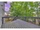 Back deck with wood railing overlooking yard and lush green trees at 6302 Manassas Nw Pass, Acworth, GA 30101