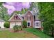 Beautiful brick home with a two-car garage and lush green lawn surrounded by mature trees at 6302 Manassas Nw Pass, Acworth, GA 30101