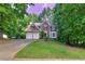 Attractive brick home featuring a two-car garage, manicured lawn, and mature trees at 6302 Manassas Nw Pass, Acworth, GA 30101