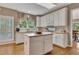 Bright kitchen offering white cabinetry, an island, stainless appliances, and beautiful hardwood floors at 6302 Manassas Nw Pass, Acworth, GA 30101