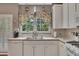 Lovely kitchen with white cabinets, wood countertops, a stainless steel sink, and pretty floral window coverings at 6302 Manassas Nw Pass, Acworth, GA 30101