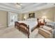 Comfortable main bedroom featuring a tray ceiling, soft lighting, and an adjoining bathroom at 6302 Manassas Nw Pass, Acworth, GA 30101