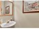 Stylish powder room with a wall-mounted sink, decorative mirror, and elegant artwork at 6302 Manassas Nw Pass, Acworth, GA 30101
