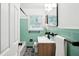 Charming bathroom with mint tile, modern vanity, and black and white flooring at 1606 Van Epps Se St, Atlanta, GA 30316