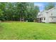 Sprawling backyard featuring lush green lawn, mature trees, and playhouse at 2060 Candlewood Ne Ct, Marietta, GA 30066