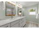 Updated bathroom featuring a double vanity, modern mirrors, and beautiful countertops, with natural light at 2060 Candlewood Ne Ct, Marietta, GA 30066