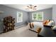 Cozy bedroom with a ceiling fan, rope chair, and a comfy bed next to natural light from the windows at 2060 Candlewood Ne Ct, Marietta, GA 30066