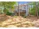 View of the rear exterior featuring a deck, stairs, and landscaped backyard surrounded by mature trees at 5396 Turnbill Nw Pt, Acworth, GA 30101