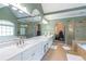 This bright bathroom features double sinks, a shower and tub with green walls and tile floors at 5396 Turnbill Nw Pt, Acworth, GA 30101