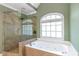 Bathroom featuring a tiled walk-in shower and soaking tub with tile surround and a window at 5396 Turnbill Nw Pt, Acworth, GA 30101