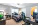 This bedroom features a window, ceiling fan, a desk with a gaming chair and a comfortable bed at 5396 Turnbill Nw Pt, Acworth, GA 30101