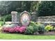 Stone entrance sign for Burnt Hickory Lakes amidst colorful flowers and lush greenery at 5396 Turnbill Nw Pt, Acworth, GA 30101
