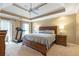 Spacious main bedroom with a tray ceiling, large bed, and treadmill at 5396 Turnbill Nw Pt, Acworth, GA 30101