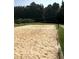 Sandy volleyball court with a net, bordered by green grass and landscaping at 5396 Turnbill Nw Pt, Acworth, GA 30101