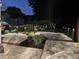 Beautiful outdoor patio area at night, with ambient lighting, lush landscaping, and sturdy black railings at 10865 Misty Moon Ct, Alpharetta, GA 30022