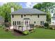 Expansive backyard view showcasing a patio, verdant lawn, and the home's light green siding at 10865 Misty Moon Ct, Alpharetta, GA 30022