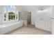 A bright bathroom features a soaking tub under a large window and a glass block shower enclosure at 10865 Misty Moon Ct, Alpharetta, GA 30022