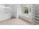 A bright bathroom features a soaking tub under a large window and a glass block shower enclosure at 10865 Misty Moon Ct, Alpharetta, GA 30022