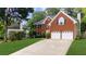 Traditional brick home with an attached two-car garage, mature trees and a well maintained lawn at 10865 Misty Moon Ct, Alpharetta, GA 30022
