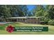Charming brick home with a lush green lawn and mature trees provides a welcoming curb appeal at 1850 Donald Dr, Marietta, GA 30062