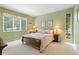 Cozy bedroom with green walls, floral bedding, and natural light, creating a serene and inviting atmosphere at 217 Millbrook Farm Rd, Marietta, GA 30068