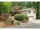 Exterior side view of home with attached garage, surrounded by lush greenery at 217 Millbrook Farm Rd, Marietta, GA 30068