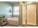 Bright bathroom features a garden tub, large glass shower, and decorative accents at 2235 Well Springs Dr Dr, Buford, GA 30519
