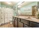 Well-lit bathroom featuring a double sink vanity with marble countertops and decorative coastal themed shower curtain at 2235 Well Springs Dr Dr, Buford, GA 30519