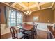 Formal dining room with coffered ceiling, wainscoting, and large windows allowing natural light at 2235 Well Springs Dr Dr, Buford, GA 30519
