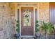 Elegant front door with decorative glass, surrounded by stone and potted greenery for added curb appeal at 2235 Well Springs Dr Dr, Buford, GA 30519