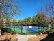 Well-maintained community tennis court surrounded by lush trees and shrubbery for year-round play at 2235 Well Springs Dr Dr, Buford, GA 30519