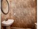 Powder room with wallpaper, pedestal sink and an oval mirror at 65 Orchard Dr, Covington, GA 30014