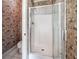 Floral bathroom featuring a glass-enclosed shower and neutral tile flooring at 65 Orchard Dr, Covington, GA 30014
