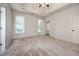 Large bedroom featuring neutral carpet, tray ceiling and two windows at 65 Orchard Dr, Covington, GA 30014