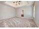 Spacious bedroom featuring tray ceilings, neutral carpet and an adjoining bathroom with a view at 65 Orchard Dr, Covington, GA 30014
