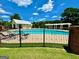 Community pool area with a pool house, lounge chairs, and fenced perimeter for safety at 65 Orchard Dr, Covington, GA 30014