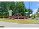 Community entrance sign with landscaping, decorative elements, and surrounding lush greenery at 65 Orchard Dr, Covington, GA 30014
