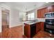 An open kitchen with stainless steel appliances and cherry wood cabinets has an adjacent dining area at 65 Orchard Dr, Covington, GA 30014