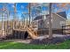 Exterior view showcasing the backyard with a wood deck, stairs leading to the yard, and black fencing for privacy at 126 Laguna Springs Dr, Woodstock, GA 30188