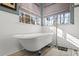 Bright bathroom with a freestanding tub, subway tile, and large windows overlooking a private backyard at 126 Laguna Springs Dr, Woodstock, GA 30188
