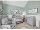 Well-lit Bedroom featuring a crib, changing table, comfortable chair, and playful decor at 126 Laguna Springs Dr, Woodstock, GA 30188