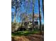 Charming home exterior featuring a deck and a well-maintained lawn, surrounded by beautiful trees at 126 Laguna Springs Dr, Woodstock, GA 30188