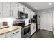 Well-lit kitchen boasts granite counters, stainless appliances, white cabinets, and stylish backsplash at 126 Laguna Springs Dr, Woodstock, GA 30188