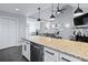Kitchen island featuring granite countertops, stainless dishwasher, and open views into the living area at 126 Laguna Springs Dr, Woodstock, GA 30188